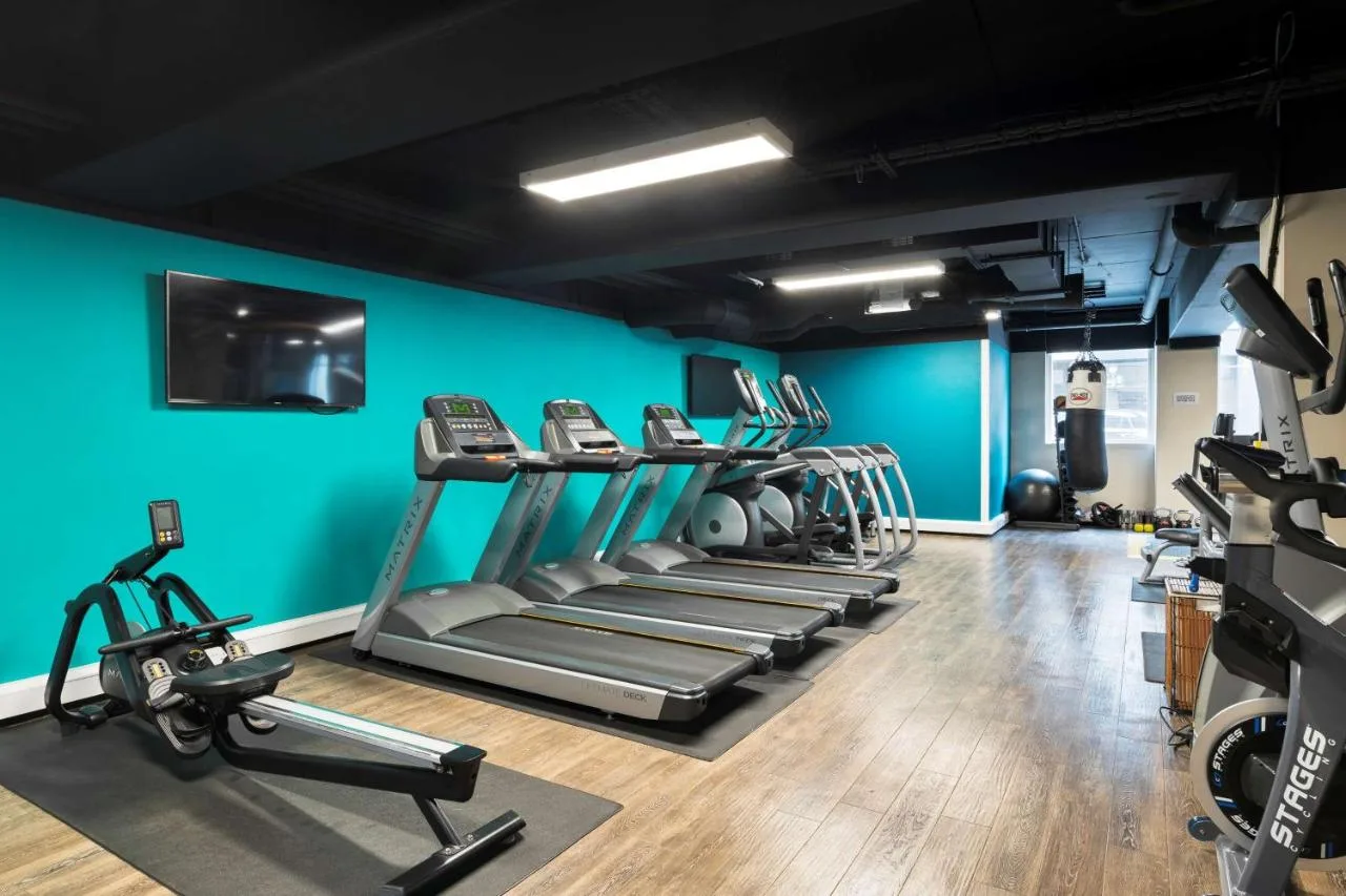 a gym with several tread machines and a blue wall at Radisson Blu Hotel, Edinburgh City Centre in Edinburgh