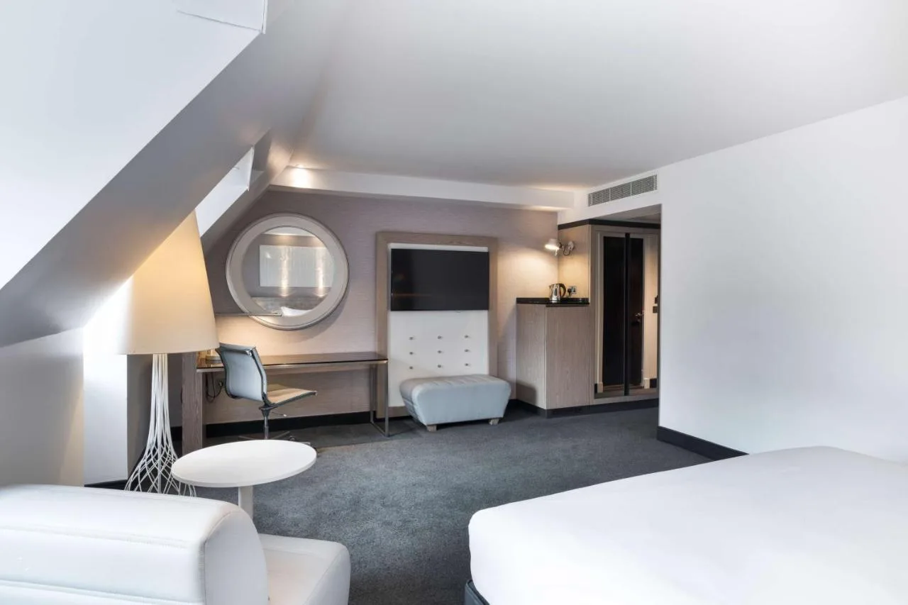 a bedroom with a bed and a table and chairs at Radisson Blu Hotel, Edinburgh City Centre in Edinburgh